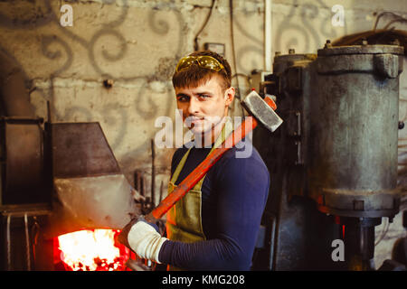 two forge are in working clothes in the forge Stock Photo