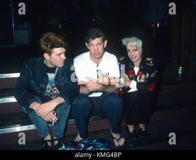 (L-R) Singer Tom Bailey of the Thompson Twins, Singer/musician Chris Isaak and singer Alannah Currie of the Thomson Twins backstage at their concert at the Greek Theatre on June 26, 1987 in Los Angeles, California. Photo by Barry King/Alamy Stock Photo