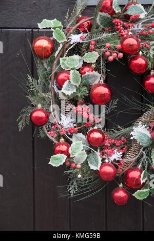 Red Ball Christmas Reef Decoration on Front Door Stock Photo