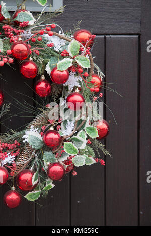 Red Ball Christmas Reef Decoration on Front Door Stock Photo