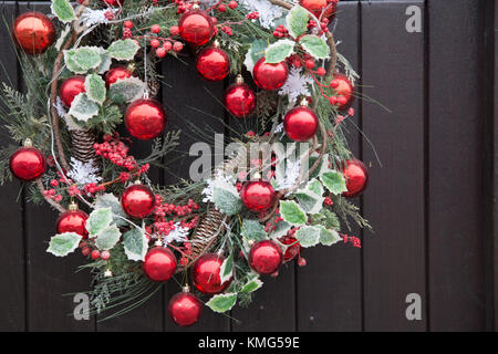 Red Ball Christmas Reef Decoration on Front Door Stock Photo