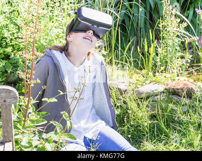 Girl using virtual reality headset at garden Stock Photo
