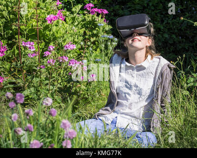 Girl using virtual reality headset at garden Stock Photo