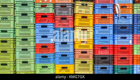 Colored plastic boxes for fruit stacked in piles Stock Photo