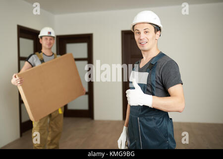 Team delivery concept. Young man worker showing thumb up Stock Photo