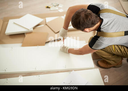 Man assembling furniture above top view in house Stock Photo