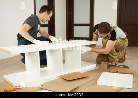 Two carpenters assembling furniture in house Stock Photo