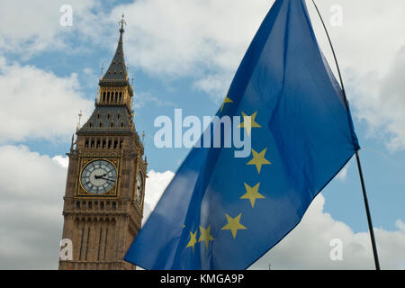 EU flag (blue/ gold stars) flapping in front and beside Big Ben, with cloudy sky. Stock Photo