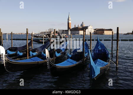 VENICE, ITALY: Gondolas are docked along the Riva degli Schiavoni near Piazza San Marco with the church of San Giorgio Maggiore seen in the distance. Stock Photo
