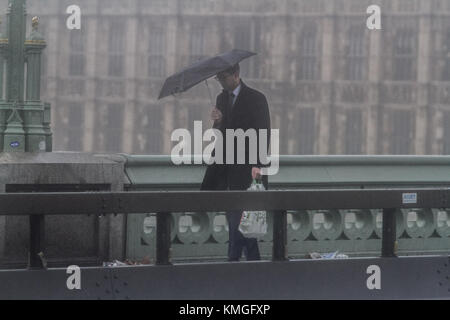 London UK. 7th December 2017. Pedestrians on Westminster are caught in  lashing rain and wind gusts as storm Caroline hits the United Kingdom bringing wind gusts up to 60mph Credit: amer ghazzal/Alamy Live News Stock Photo