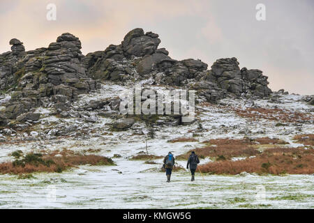 Hound Tor, Dartmoor, UK.  8th December 2017.  UK Weather.  Walkers enjoying the light dusting of snow which covers the landscape at Hound Tor in the Dartmoor National Park in Devon on a day of snow showers and cold temperatures.  Picture Credit: Graham Hunt/Alamy Live News Stock Photo