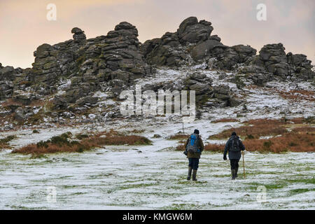 Hound Tor, Dartmoor, UK.  8th December 2017.  UK Weather.  Walkers enjoying the light dusting of snow which covers the landscape at Hound Tor in the Dartmoor National Park in Devon on a day of snow showers and cold temperatures.  Picture Credit: Graham Hunt/Alamy Live News Stock Photo