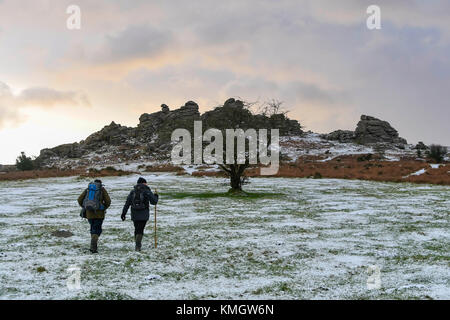 Hound Tor, Dartmoor, UK.  8th December 2017.  UK Weather.  Walkers enjoying the light dusting of snow which covers the landscape at Hound Tor in the Dartmoor National Park in Devon on a day of snow showers and cold temperatures.  Picture Credit: Graham Hunt/Alamy Live News Stock Photo