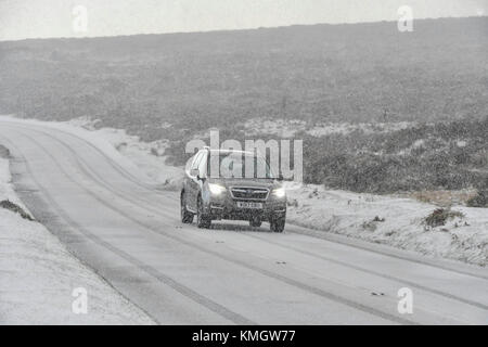 Haytor, Dartmoor, UK.  8th December 2017.  UK Weather.  A car driver taking it slowly as a heavy snow shower falls making driving treacherous on the B3387 near Haytor in the Dartmoor National Park in Devon. Picture Credit: Graham Hunt/Alamy Live News Stock Photo