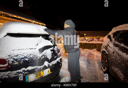 Flintshire, North Wales, 11th December 2017, UK Weather. With a Met Office Yellow Warning for icy conditions for many today. Commuters will wake up to a hard-packed snow and black ice and what the press are calling ‘Black Monday’. A commuter starting early to clear cars on a driver way of snow and ice before attempting to make the morning commute to work in the village of Lixwm, Flintshire © DGDImages/Alamy Live News Stock Photo