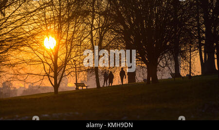 London, UK. 12th Dec, 2017. London, December 12 2017. Walkers on Primrose Hill as the sun rises on a clear very cold morning in London. Credit: Paul Davey/Alamy Live News Stock Photo