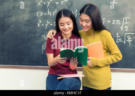 Two Asian students studying together in classroom at university. University student. Stock Photo