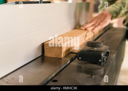 Hand using electric planer and wooden beam Stock Photo