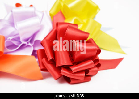 closeup of some satin gift ribbon bows of different colors on a white background Stock Photo