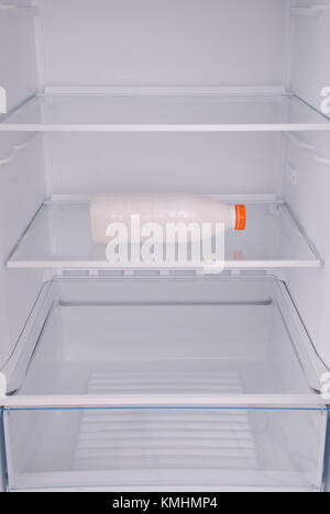 Bottle of milk inside in empty clean refrigerator with opened door Stock Photo