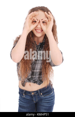 Portrait of a funny young girl looking at camera through fingers isolated on a white background Stock Photo