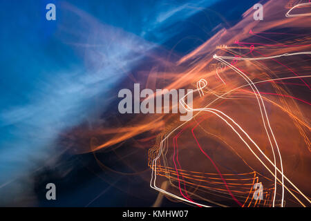 slow motion abstraction on the road. blurred background of car light traces and cloudy night sky. traffic wild energy concept Stock Photo