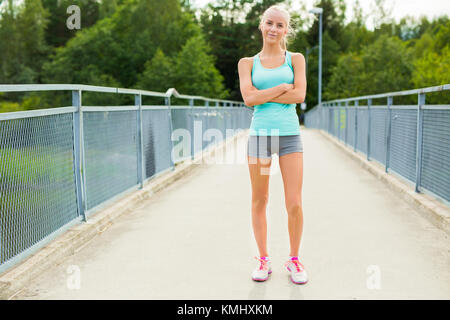 Confident and smiling young female runner having break after workout Stock Photo