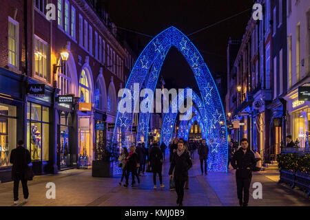 People walking along South Molton St at Christmas time, which has been decorated with large blue Christmas arches, London, UK Stock Photo