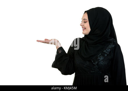studio shot of young woman wearing traditional arabic clothing. she's holding her hand to the side Stock Photo