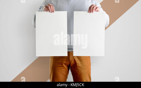 Two Template mocup posters in the hands of men. White forms of a flyer in hand, isolated against a background with a diagonal strip. Stock Photo