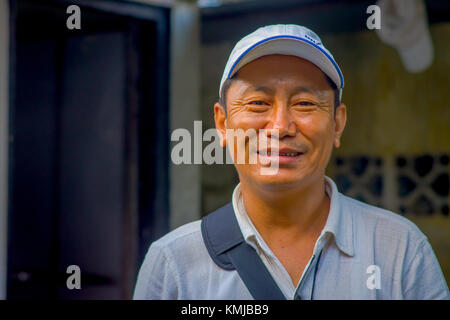 POKHARA, NEPAL - OCTOBER 06 2017: Portrait of Tibetan man posing for camera and wearing hat in Tashi ling village. Tashi Ling is one of the tibetan refugee camp in Nepal Stock Photo