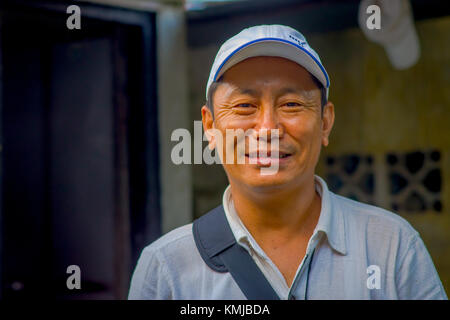 POKHARA, NEPAL - OCTOBER 06 2017: Portrait of Tibetan man posing for camera and wearing hat in Tashi ling village. Tashi Ling is one of the tibetan refugee camp in Nepal Stock Photo