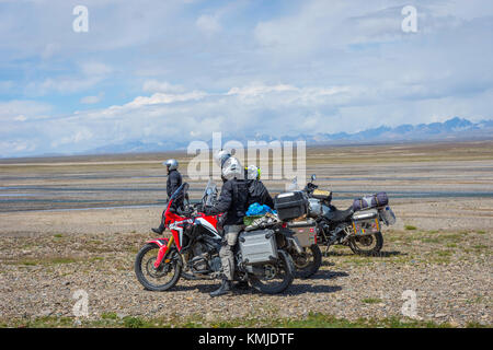 KEL-SUU, KYRGYZSTAN - AUGUST 13: Group of motorbikers overlooking scenic valley in Tian Shan mountains with the river. August 2016 Stock Photo