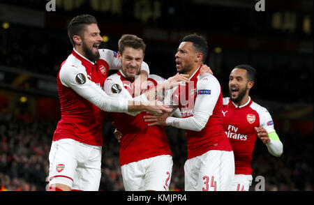 Arsenal's Mathieu Debuchy (centre) celebrates scoring his side's first goal of the game with team mates Arsenal's Olivier Giroud (left), Arsenal's Theo Walcott (right) and Arsenal's Francis Coquelin (second right) during the UEFA Europa League, Group H match at the Emirates Stadium, London. Stock Photo