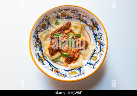 Ravioli stuffed with goat cheese, with a tomato sauce, Parmigano-Reggiano cheese and fresh green basil Stock Photo