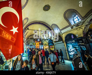 Unidentified Tourists visiting and shopping in the Grand Bazaar in Istanbul. Interior of the Grand Bazaar with Turkish Flag on the foreground.Istanbul Stock Photo