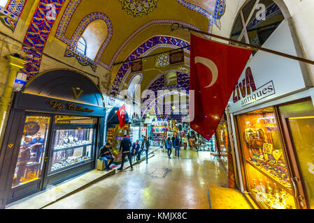 Unidentified Tourists visiting and shopping in the Grand Bazaar in Istanbul. Interior of the Grand Bazaar with Turkish Flag on the foreground.Istanbul Stock Photo