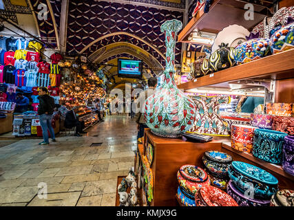 Unidentified Tourists visiting and shopping in the Grand Bazaar in Istanbul. Interior of the Grand Bazaar with souvenirs on the foreground.Istanbul, T Stock Photo