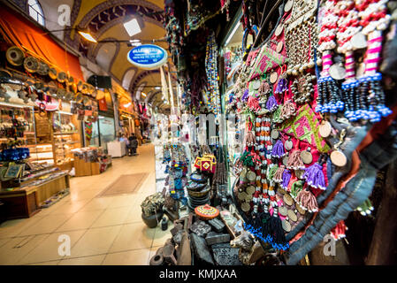 Unidentified Tourists visiting and shopping in the Grand Bazaar in Istanbul. Interior of the Grand Bazaar with souvenirs on the foreground.Istanbul, T Stock Photo