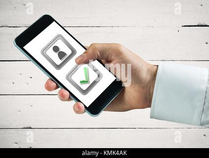 Digital composite of Hand holding phone with user feedback and correct tick button Stock Photo