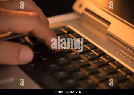 Man pressing a key on a laptop keyboard Stock Photo