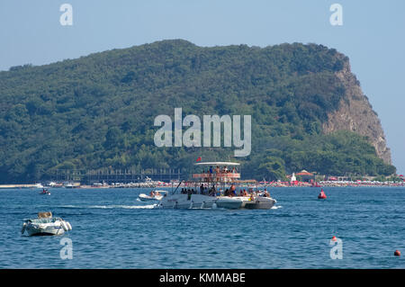 Montenegro, Budva, Walking catamaran sails near the shore of Sveti Nikola Island, Budva gulf, Adriatic Sea Stock Photo