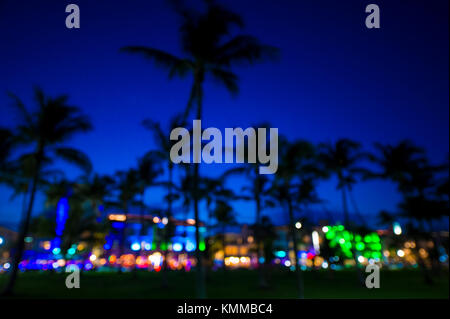 Defocused view at dusk of palm trees and neon lights of Ocean Drive as viewed from Lummus Park in South Beach, Miami, Florida Stock Photo