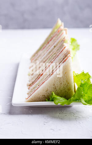 English tea sandwiches platter on white plate over light background Stock Photo