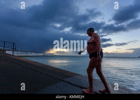 Penzance, Cornwall, UK, 8th December 2017. Early morning, and open water swimmer Bob Anderson exits the sea on one of the coldest UK days of the year. Stock Photo