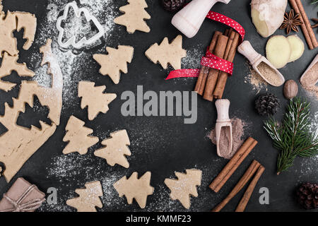 Cooking tools and ingredients from above. Baking concept with measuring  spoons, wooden scoops, whisks, cookie cutters, sugar, flour, eggs and  cinnamon on a modern concrete background with copy space Stock Photo