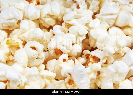 Scattered salted popcorn, food texture background. Fastfood popular during a movie in a cinema. Popcorn texture. Stock Photo