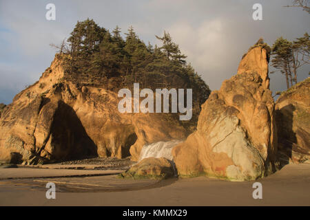 Waterfall and coastal rocks at dusk, Hug Point State Park, Oregon Stock Photo