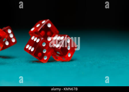 Photo of several red dice falling on green table Stock Photo