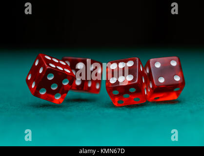 Picture of several red dice falling on green table on black background Stock Photo